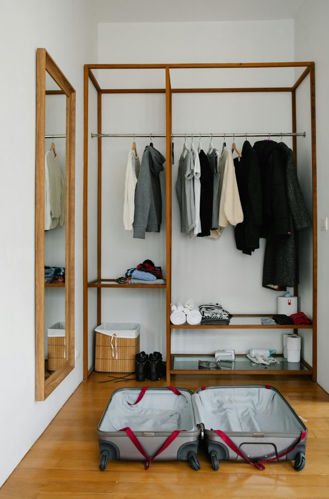 Travel clothing essentials laid out for packing, including shirts, pants, and layers