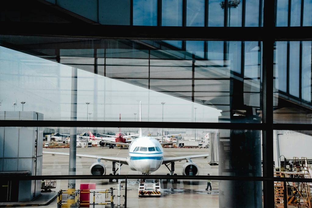 View of an airplane at Shanghai airport terminal, framed by modern architecture.